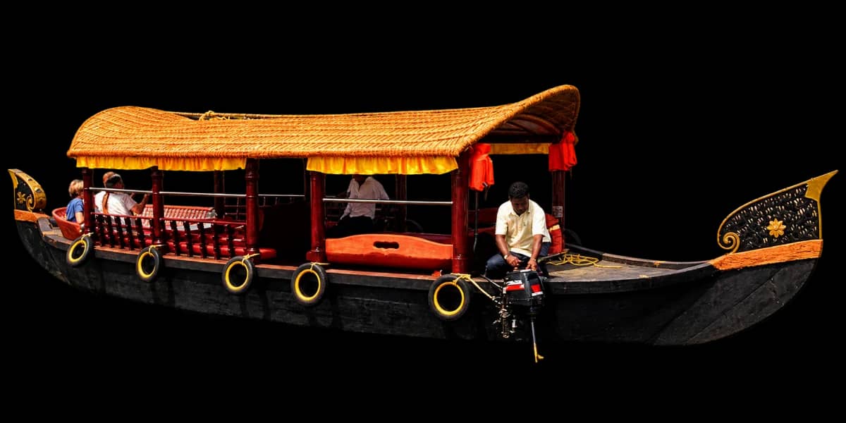 Traditional Poovar shikara boat with a golden canopy and carved wooden prow