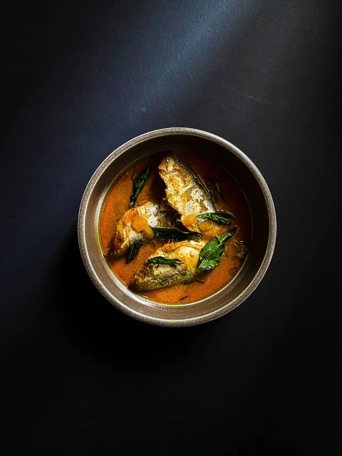 Traditional Kerala seafood meal featuring fresh fish curry (meen curry) and local coastal cuisine in Kovalam